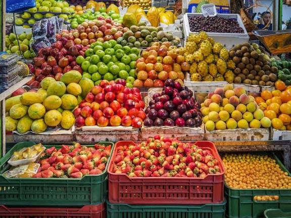 Pemilik toko buah mengatur stok dan menata buah segar di area penjualan
