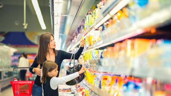 Karyawan melayani pelanggan dengan ramah di dalam toko retail yang rapi